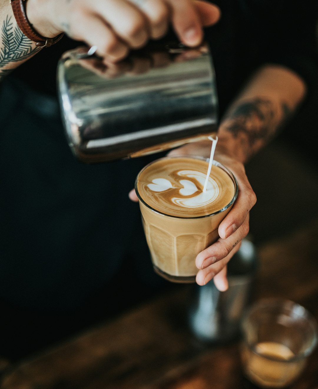 Gros plan sur un verre de café latte pendant la réalisation d'un art latte