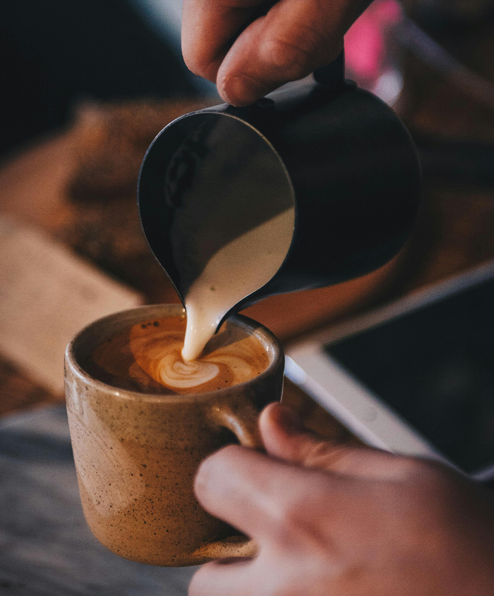 Gros plan sur un tasse de café pendant la préparation d'un art latte