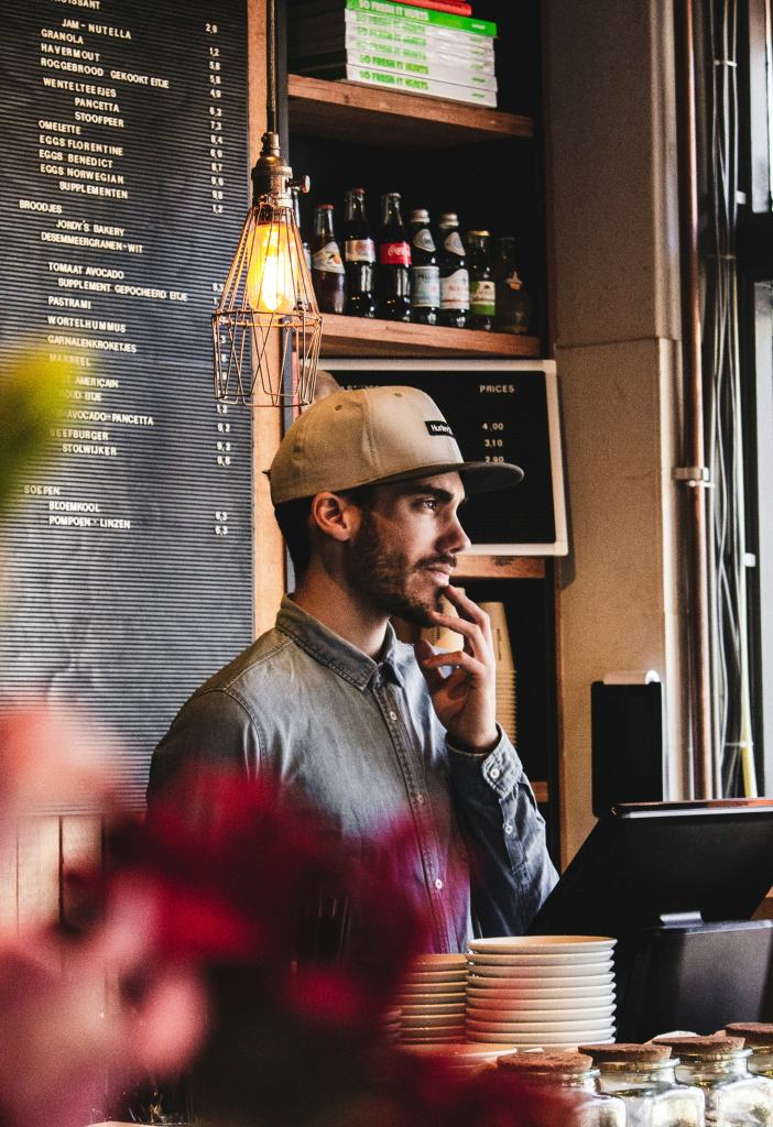 Un jeune barista derrière son écran de commande