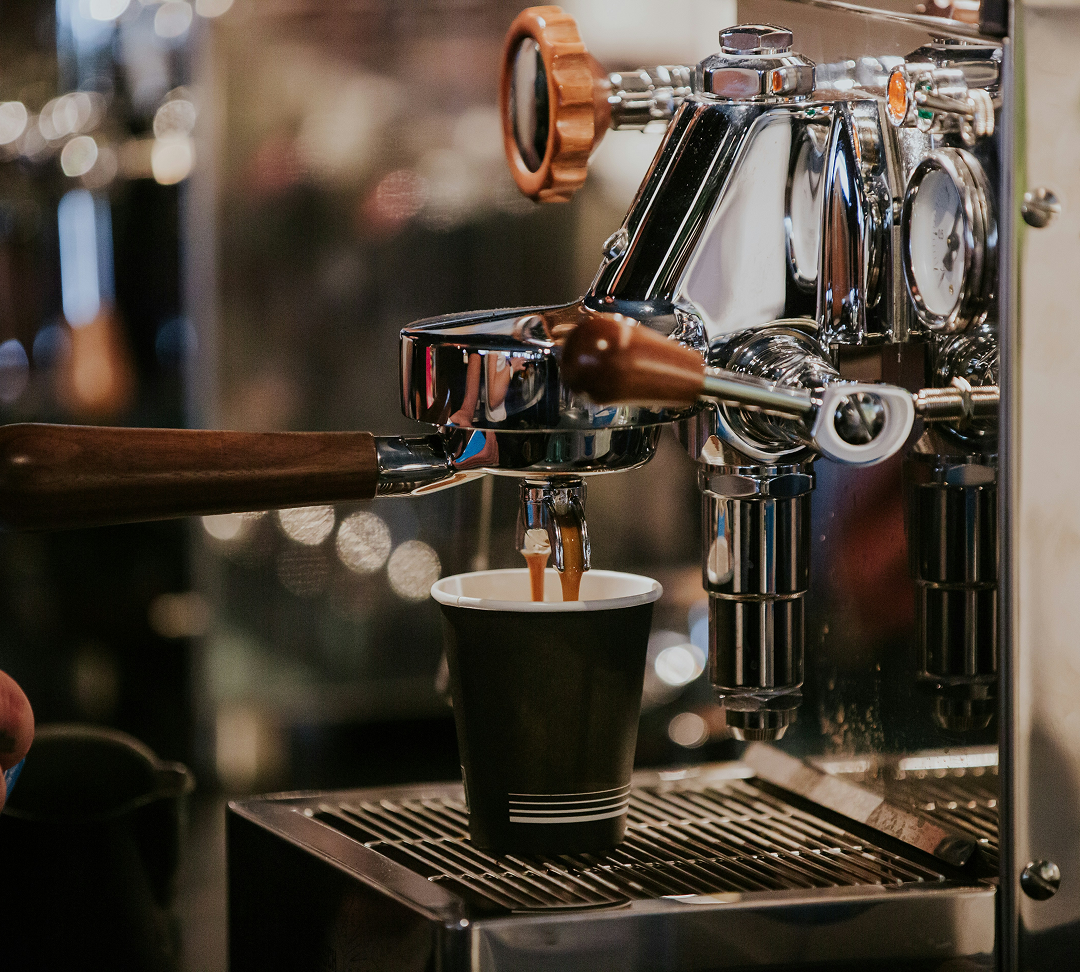 Une machine à café en fonction, avec un gobelet