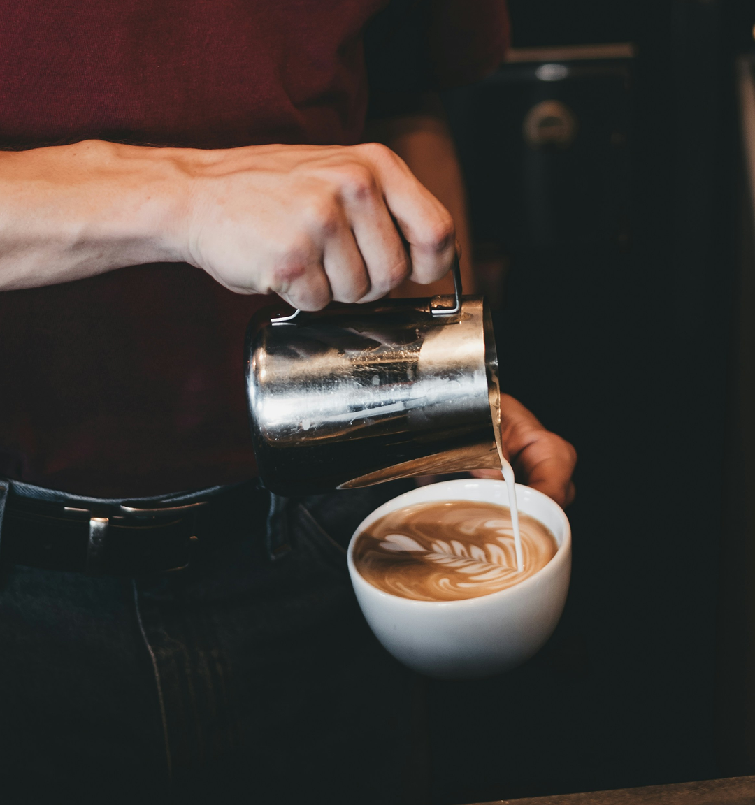Un barista crée un art latte sur un café latte